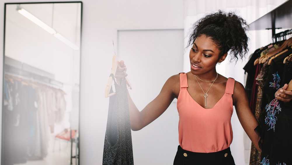 Image of a woman sorting dresses on a rack