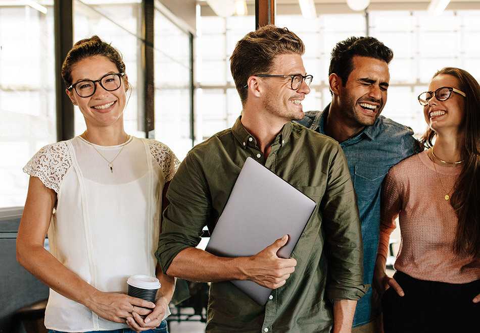 2 females and 2 man walking in a group and smiling